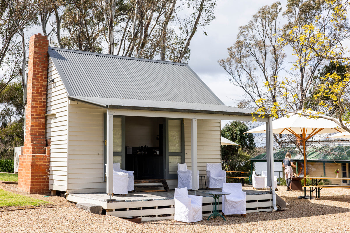 Cellar Door with outdoor seating area and trees in the background